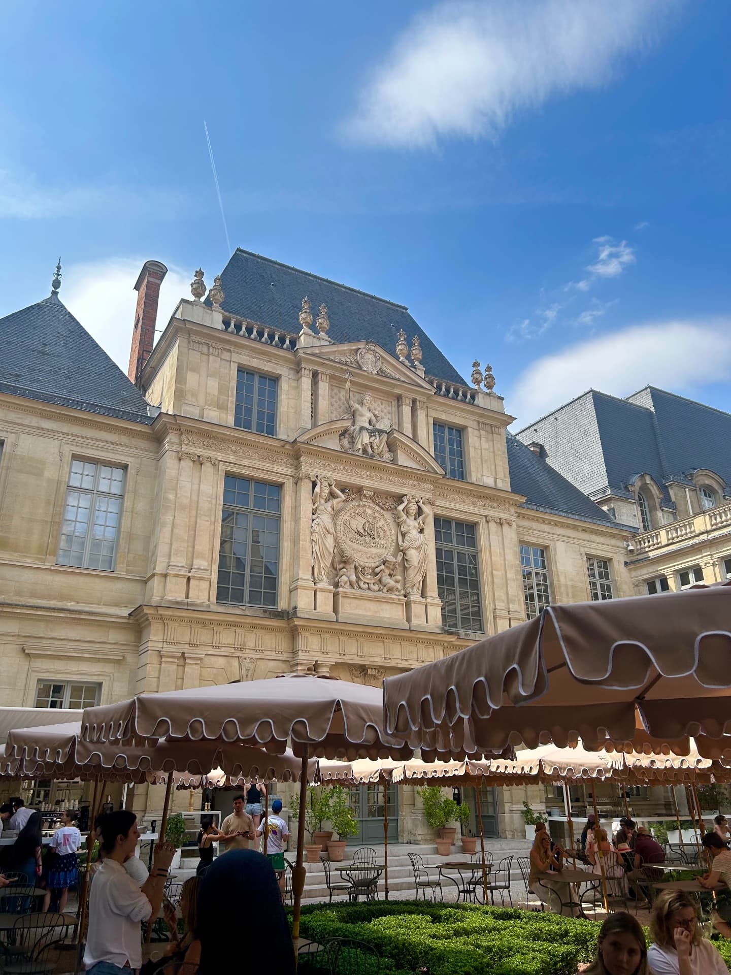 Terrasse de café sous les parasols dans une cour du Marais